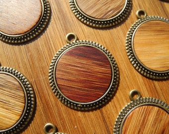 Könnte beinhalten: Ein Set aus sieben runden Holzanhängern mit einem goldfarbenen Metallrahmen. Die Anhänger haben eine Holzmaserung und sind perfekt zum Basteln von Schmuck.