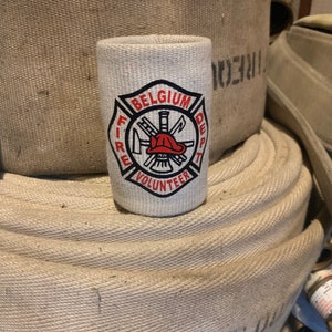 May include: White can cooler with a black and red fire department logo. The logo says "Belgium Fire Dept Volunteer".