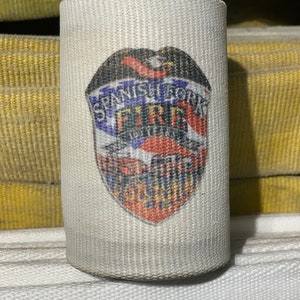 May include: A white fire hose with a red, white, and blue patch that says "Spanish Fork Fire Department".