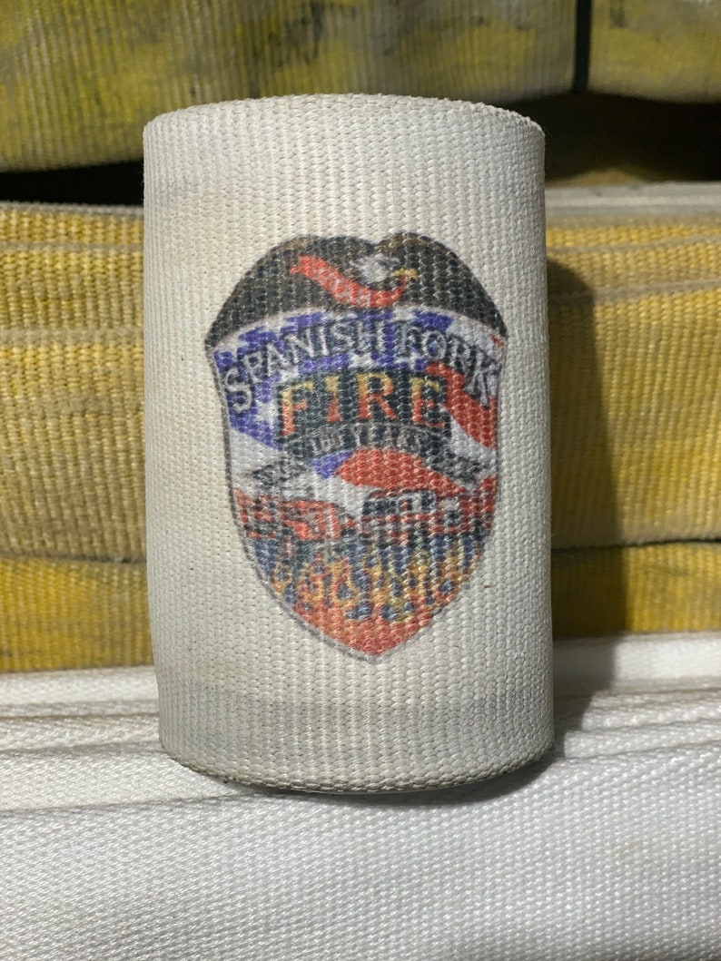 May include: A white fire hose with a red, white, and blue patch that says "Spanish Fork Fire Department".