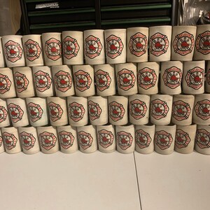 May include: A stack of white foam can coolers with a red and black logo that says "Belgium Fire Dept. Volunteers".