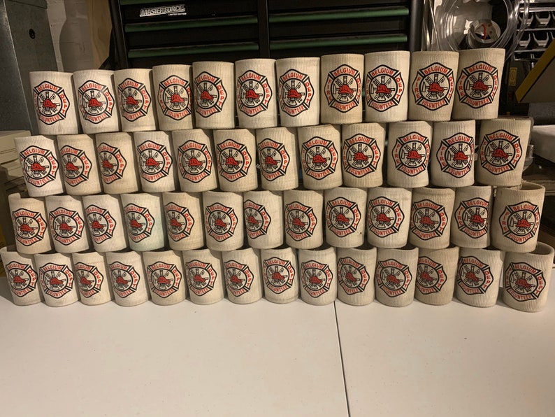 May include: A stack of white foam can coolers with a red and black logo that says "Belgium Fire Dept. Volunteers".