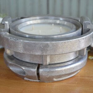 May include: A silver metal candle holder shaped like a fire hydrant with a white candle inside.