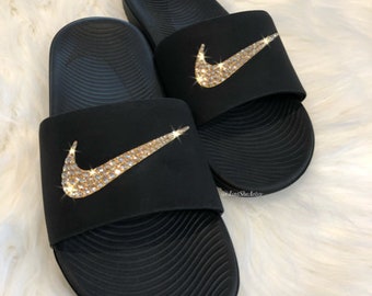 black nike slides with gold check