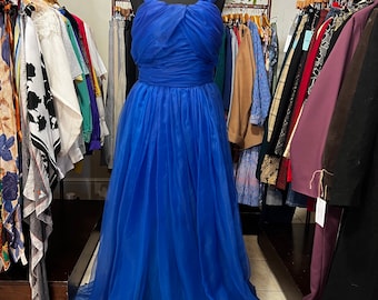 May include: A royal blue tulle gown with a sweetheart neckline and a fitted bodice. The gown has a flowing skirt and a train.
