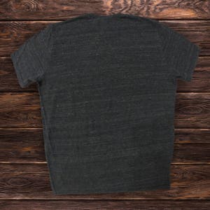 May include: A dark gray t-shirt with a plain front. The shirt is made of a soft, comfortable fabric and has a relaxed fit.
