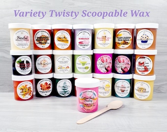 May include: A variety of 16 small, clear glass jars filled with colorful, scented wax. The jars are labeled with different scents, such as "Frosted Almond Croissant", "Pumpkin French Toast", "Hot Cocoa", "Fresh Margarita", "Pie or Leaves", "Fraser Fir", "Cotton Candy Frosting", "Cupcakes at Tiffanys", and "Eggnog French Toast". A wooden spoon is lying on the table in front of the jars.