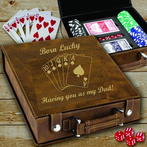 May include: A brown leather poker set with the text "Born Lucky" and "Having you as my Dad!" engraved on the lid. The set includes playing cards, poker chips, and dice. A royal flush is displayed on the lid.