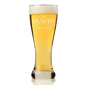 May include: A tall, clear glass beer mug with a frosted rim and a white inscription that reads "Murphy Est. 2018".