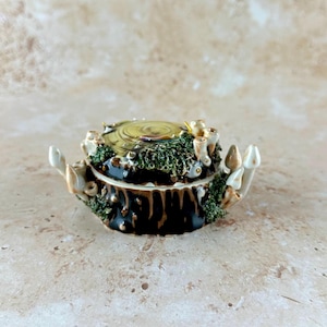 May include: A set of three ceramic mugs with a speckled, matte finish. The mugs are in shades of cream, light gray, and dark gray. Each mug has a simple, minimalist design, perfect for coffee or tea.