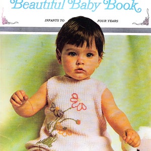 Könnte beinhalten: Ein Vintage-Buchcover mit einem Baby, das ein rosa gestricktes Kleid mit gestickten Blumen trägt. Der Titel lautet "Beautiful Baby Book, Infants to Four Years" und "Columbia Minerva, Book 766, Price $1.50".
