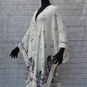 Easy comfy loosefitting ruana style cover-up jacket. V neck. Sleeveless.Vintage button closure.Tiny flora on cream ground.Washable.