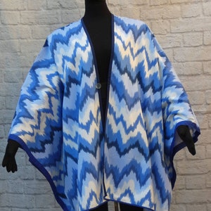 Vibrant blue white chevron,herringbone stripe ruana-style cover-up caftan.Navy blue decorative binding.Front vintage button closure.Washable