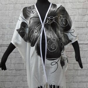 Lightweight cotton gauze cover-up duster. Handpainted tropical blossoms.Fringed hem. Banded front,neckline. Hook+eye closure. Washable.