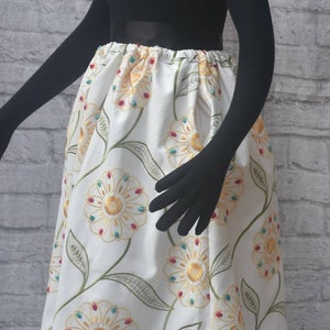 Embroidered linen midi skirt. Has lining , elasticized waistband and side seam pockets. Vivid Floral embroidery. Below knee length.
