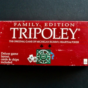 May include: A red Tripoley family edition game box. The box features white text that reads "TRIPOLEY" and "THE ORIGINAL GAME OF MICHIGAN RUMMY, HEARTS & POKER". The box also includes a deluxe game layout, cards, and chips.