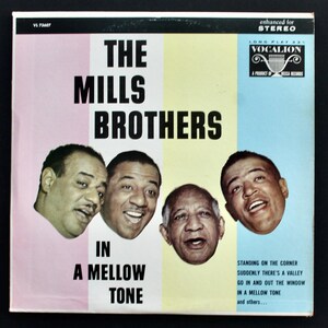 May include: Vintage vinyl record album cover for "The Mills Brothers In A Mellow Tone." The cover features four headshots of the band members against a backdrop of pink, yellow, and blue vertical stripes. The album title and band name are in bold black text.