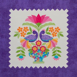 May include: A colorful quilt block with two purple peacocks in a green vase with pink, orange, and yellow flowers. The background is white with a purple scalloped border.