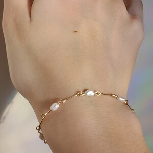 Dainty and delicate thin golden wire bracelet with white natural pearl beads, delivered in environment friendly compostable package