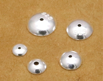 May include: Four silver-toned metal bead caps with a hole in the centre. The caps are different sizes and have the number "925" stamped on them.