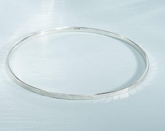 Può includere: Un braccialetto semplice in argento con finitura martellata.