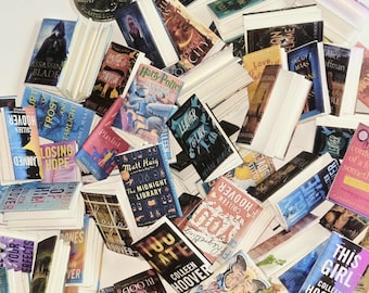 May include: A collection of miniature books with various titles and colorful covers, including "Harry Potter" and "This Girl." A US quarter is also present. The books are arranged on a white surface, suggesting a literary theme.