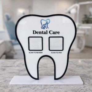 以下が含まれることがあります： 黒い縁取りのある白い歯の形をしたサインで、「Dental Care」の文字と2つの正方形のスキャンエリアがあります。サインには「SCAN TO REVIEW」と「SCAN TO PAY」の文字も含まれています。青い歯科ロゴが上部にあります。