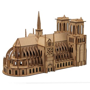 May include: A wooden model of Notre Dame Cathedral. The model is constructed from light brown wood and features detailed elements such as arched windows, spires, and a rose window. The cathedral model is a detailed replica of the famous landmark.