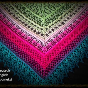 May include: A colorful, crocheted shawl in a V-shape, featuring a gradient of colors from green to turquoise. The shawl has a delicate, openwork design with a scalloped edge. The text "Deutsch, English, Suomeksi" is visible.