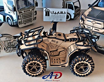May include: Wooden model of an all-terrain vehicle (ATV) with the text "800 G" on the side. The ATV is surrounded by other wooden vehicle models, including a truck, motorcycle, and car. The models are made of light brown wood with black accents.