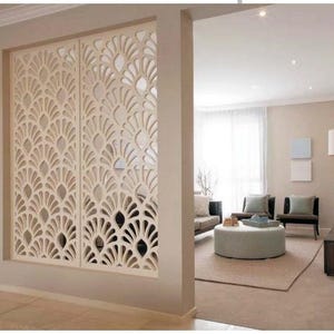 Pode incluir: Divisor de ambientes decorativo creme com um padrão repetitivo em forma de leque. O divisor é instalado em uma porta, separando dois cômodos. O design permite a passagem da luz, criando uma sensação de abertura. Um elemento de design de interiores elegante.