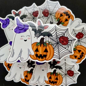 May include: A set of Halloween stickers featuring a ghost wearing a purple hat, a bat, a spiderweb with a red spider, and a jack-o'-lantern.