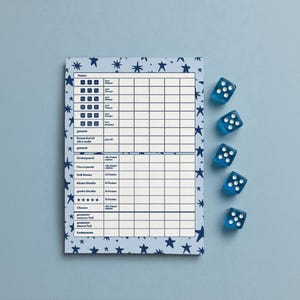 May include: A rectangular score sheet with a light blue background and dark blue star pattern, featuring a grid for game scoring. Five translucent blue six-sided dice with white pips are arranged in a vertical column to the right of the sheet.