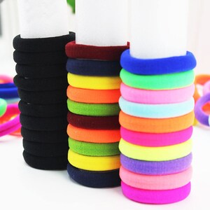 Puede incluir: Un conjunto de gomas para el pelo de colores en varios colores, incluyendo negro, rojo, azul, verde, amarillo, naranja, rosa y morado. Las gomas para el pelo est&aacute;n hechas de un material suave y el&aacute;stico, perfectas para sujetar el pelo en su lugar.