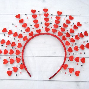 May include: A red headband with a circle of red felt hearts and black and white beads hanging from each heart.
