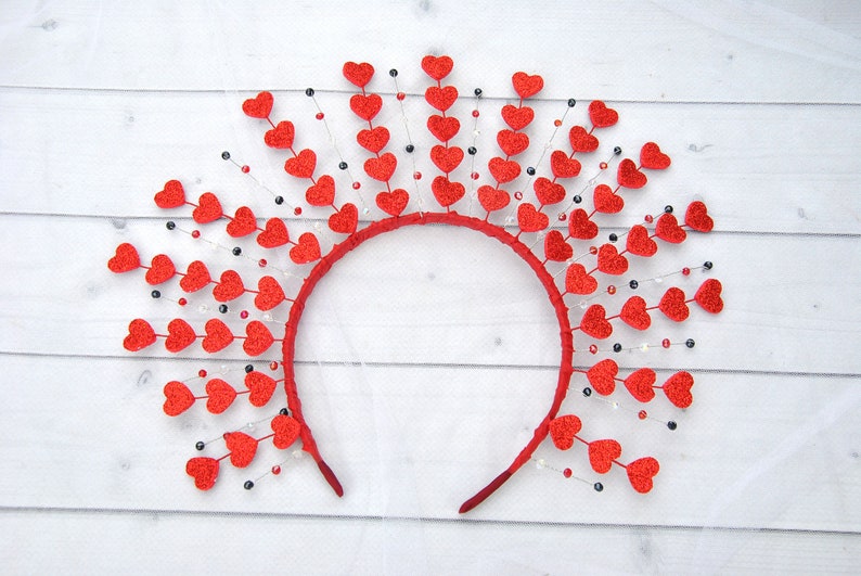 May include: A red headband with a circle of red felt hearts and black and white beads hanging from each heart.