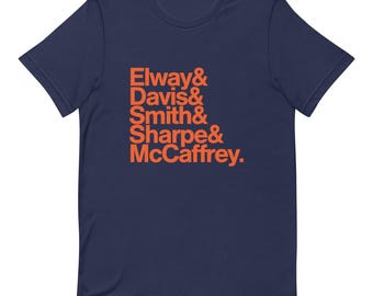 Può includere: T-shirt blu navy con il testo "Elway & Davis & Smith & Sharpe & McCaffrey." in arancione.