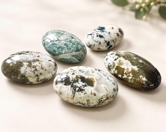 May include: Five smooth, polished oval stones featuring mottled patterns in shades of forest green, olive, white, and dark charcoal. Each stone has a glossy, reflective surface with unique organic inclusions and varied color distributions.