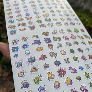 May include: Sheet of colorful pixel art stickers featuring various cartoon creatures. The stickers are in a variety of colors, including blue, green, yellow, and red. The stickers are on a white background.