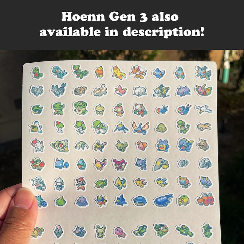 May include: A sheet of colorful stickers featuring various pixelated creatures. The stickers are arranged on a white background and held by a hand. The text "Hoenn Gen 3 also available in description!" is at the top.