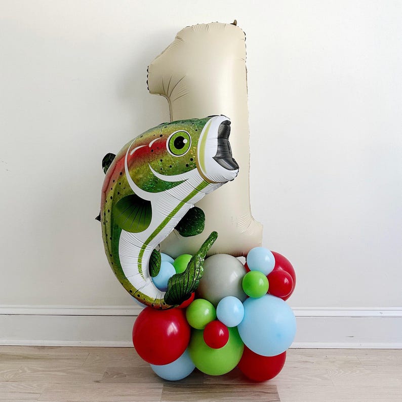 A balloon bouquet in the shape of the number one, with a fish-shaped balloon on top, and various colored balloons surrounding it.
