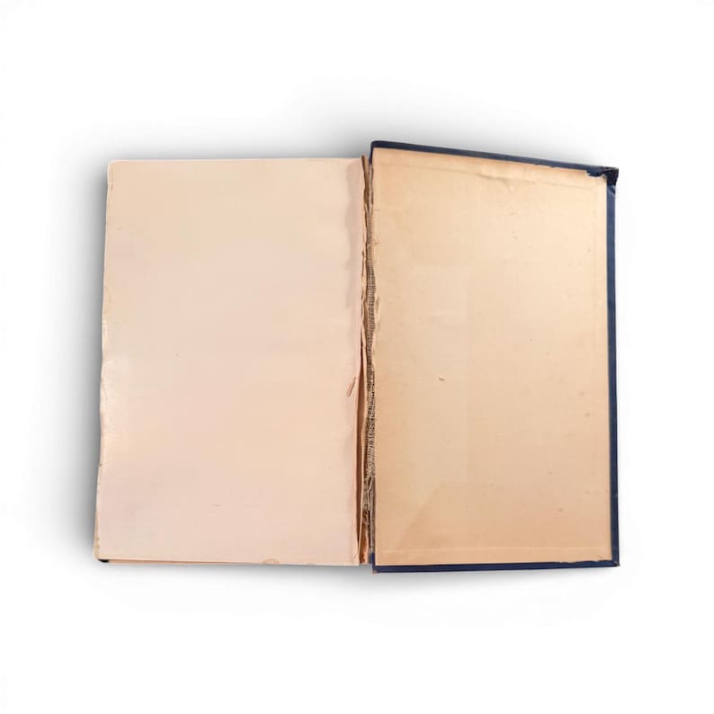 May include: An open book with aged, cream-colored pages. The book's spine is dark blue, and the pages show signs of wear and age. The book is set against a white background, highlighting its vintage appearance.