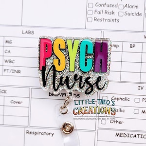 Puede incluir: Un portatarjetas colorido con las palabras "PSYCH Nurse" en vibrantes colores del arcoíris. La insignia tiene un borde brillante y un carrete de plástico transparente con un broche metálico. También se ve el texto "Little Theo's Creations".