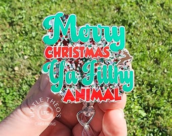 May include: A green, red and white glitter badge holder with the text "Merry Christmas Ya Filthy Animal".