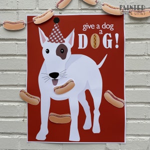 May include: A red and white printable game board with a white bull terrier wearing a red and white checkered party hat. The dog is looking up with its mouth open and has a hot dog in its mouth. The text on the board reads "give a dog a DOG!" and "painted white lines".