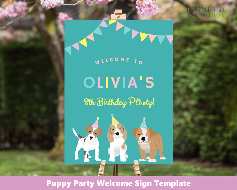 May include: A teal sign with the text "WELCOME TO OLIVIA'S 8th Birthday Party!" and illustrations of three puppies wearing party hats. The sign has a banner of colorful flags at the top and is displayed on a wooden easel.