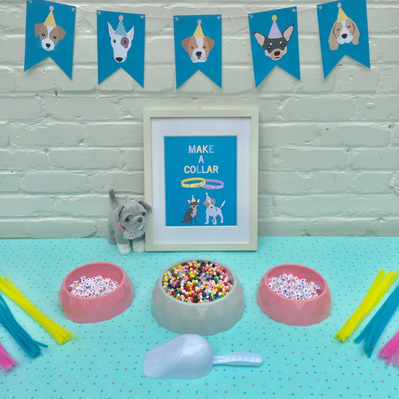 May include: A craft table set up for a dog-themed party. There are three bowls filled with colorful beads, a scoop, and a sign that says "Make a Collar".