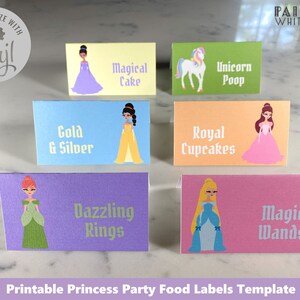 May include: Printable food labels for a princess party. The labels feature different princess characters and food items, such as "Magical Cake", "Unicorn Poop", "Gold & Silver", "Royal Cupcakes", "Dazzling Rings", and "Magic Wands".
