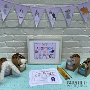 May include: A white frame with a pink background and the text "PET ADOPTION CENTER" in rainbow letters.  There are stuffed animals in boxes with tags that say "LULU", "ANGUS", "SADIE", and "ROCKY".  There are also pencils and a certificate of adoption.