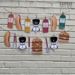 Pu&ograve; includere: Uno striscione di compleanno rosso, bianco e blu a tema barbecue. Lo striscione include immagini di hot dog, hamburger, griglie, ketchup, senape e salsa. Lo striscione include anche il testo "Happy Birthday Kai", "Grill 'n Chill", "Moo Hoodi Kai 21", "Let's Ketchup Dude", "Relish the Day", "Let's Go Kai" e "2".